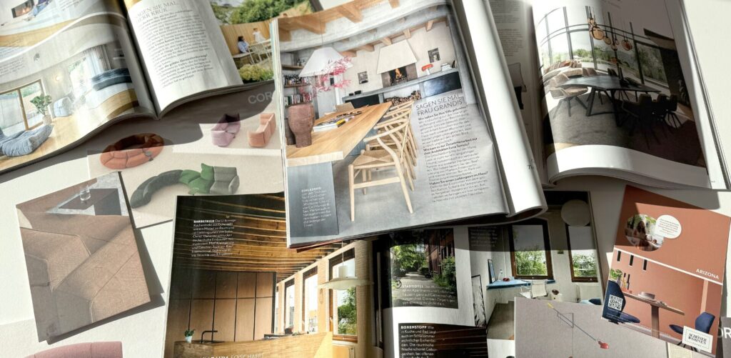 Aufgeschlagene Interior-Zeitschriften mit Einrichtungsbildern - Inspiration sammeln für persönlichen Wohnstil